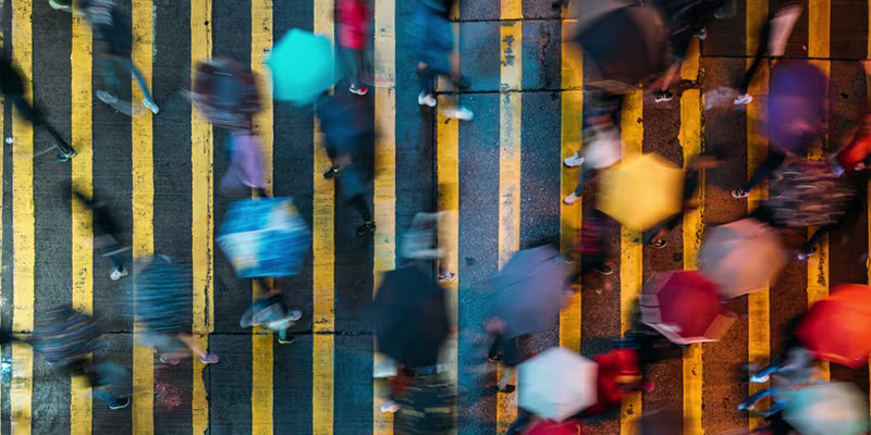 People crossing the street in the rain with colourful umbrellas