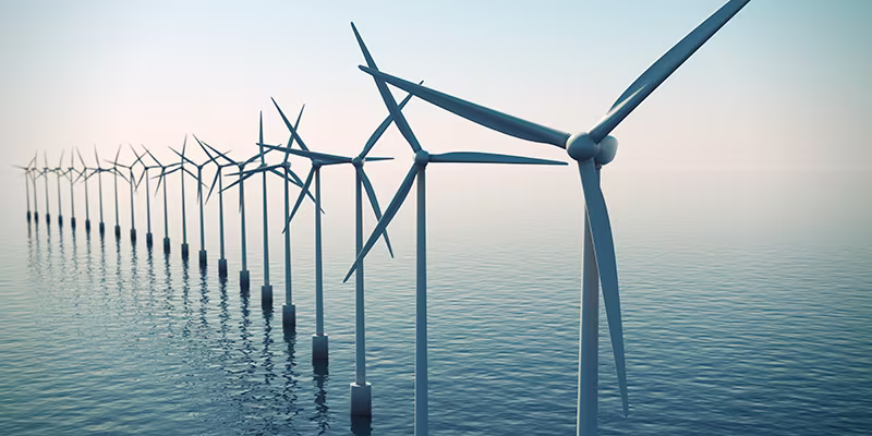 Row of floating wind turbines during hazy day.
