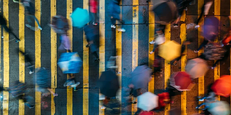 People crossing the street in the rain with colourful umbrellas