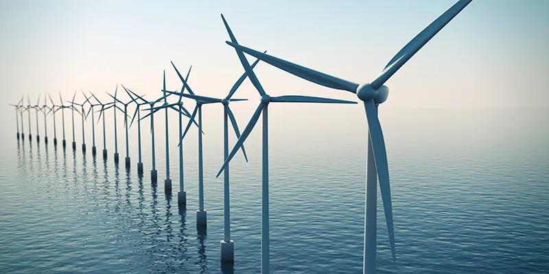 Row of floating wind turbines during hazy day.