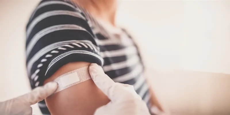 Doctor putting on a bandaid after vaccination