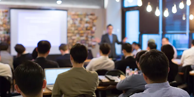 People in a meeting room with a presenter in the front